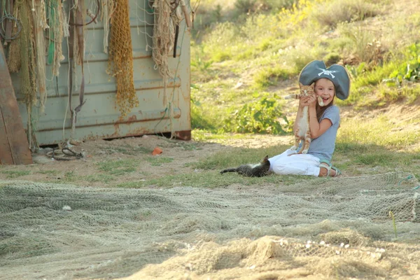 Schattig klein meisje in een pirate hat houden weinig kitten in de natuur — Stockfoto