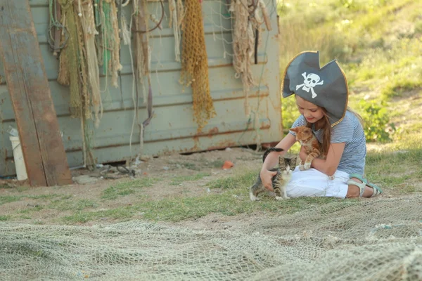 Fröhlich lächelndes kleines Mädchen spielte mit einem kleinen Kätzchen im Freien — Stockfoto