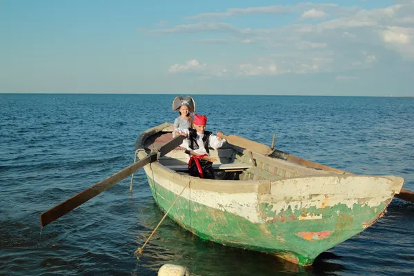Joyeux jeunes enfants jouant aux pirates dans le vieux bateau sale dans la mer — Photo