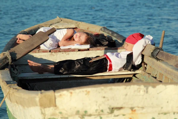 Garçon Pirate et sa dame dormant dans un vieux bateau sur le fond de la mer bleue — Photo