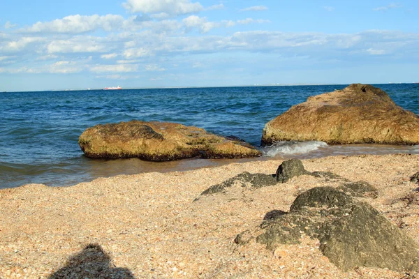 Zee landschap met grote stenen in de zee en op de oever op een zonnige zomerdag — Stockfoto