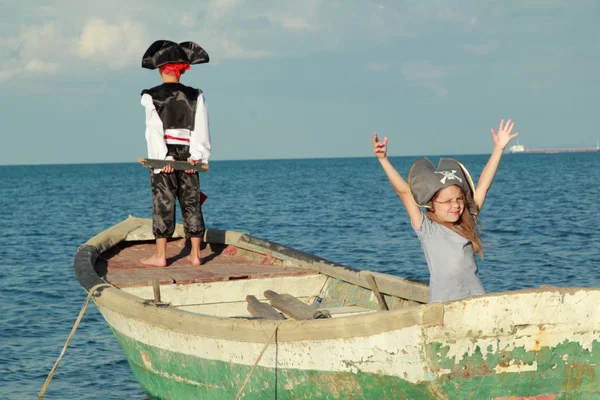 Sonriendo alegre niño y niña jugando en el pirata vestido con trajes y sombreros —  Fotos de Stock