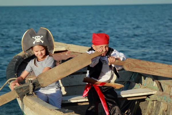 Caucasian joyful little children playing pirates on the sea — Stock Photo, Image