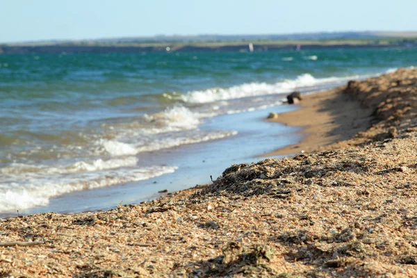 Schöne Meeresküste mit Sand und Steinen — Stockfoto