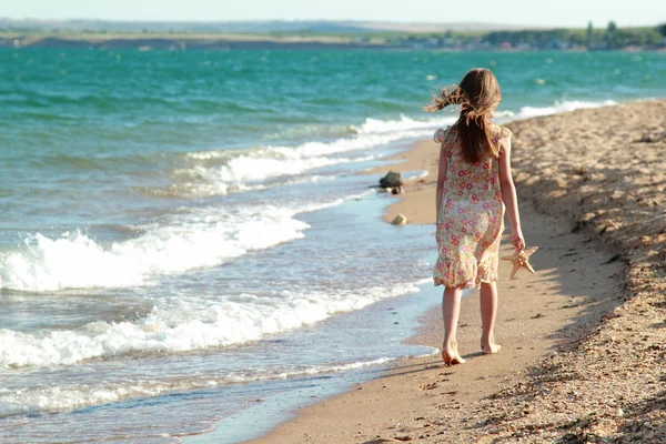 一个微笑的小女孩，在沙滩上的肖像. — 图库照片