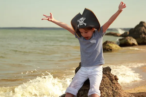 Beautiful angry little girl in pirate fancy dress on a background of a sea landscape — Stock Photo, Image