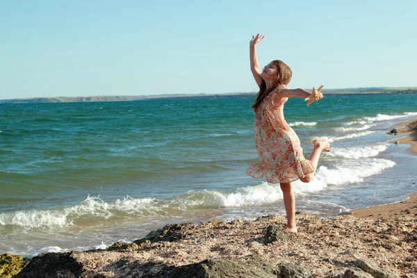 Adorabile bambina felice che tiene una stella marina sulla spiaggia nella giornata di sole — Foto Stock