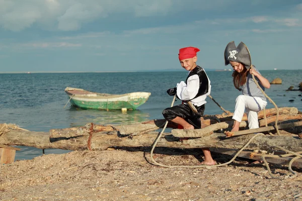 Caucasian joyful little children playing pirates on the sea — Stock Photo, Image