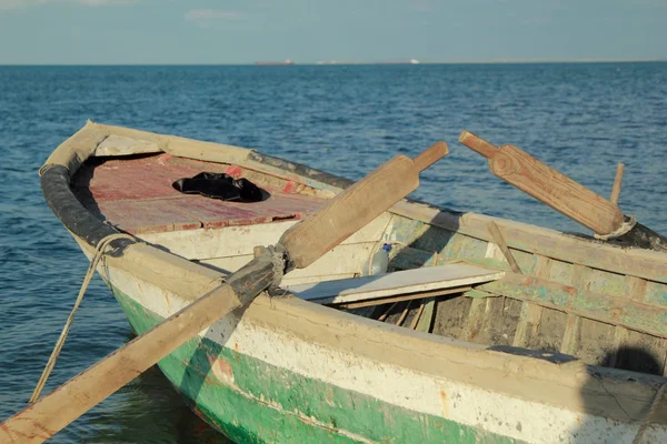 Старий човен з веслами в море на якорі — стокове фото