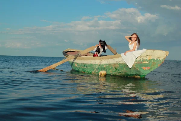 Bella sorridente giovane ragazzo e ragazza come un pirata e una signora che nuota nella vecchia piccola barca — Foto Stock