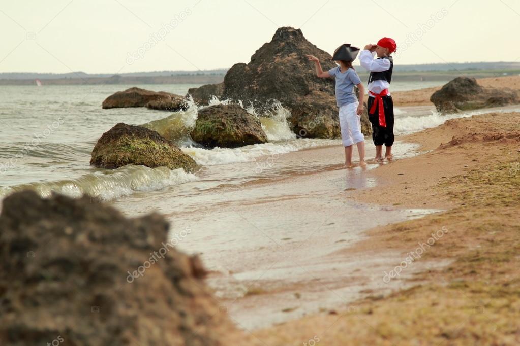 Caucasian cute kids play pirates on the sea