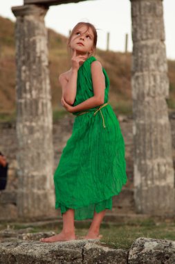Beautiful little Greek goddess in emerald green dress. clipart