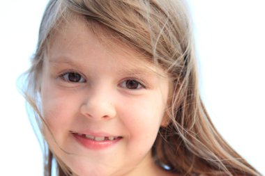Caucasian lovely little girl smiling on a background of blue sea