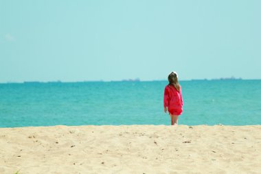 sevimli küçük kız var eğlenceli bir kumsala arka plan üzerinde