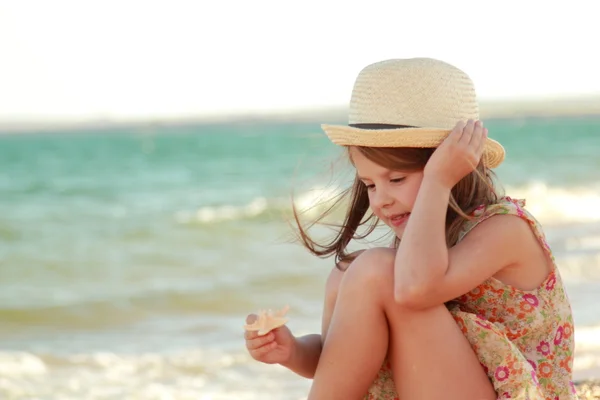 Lovely girl with a beautiful smile playing barefoot in the water on the beach — Stock Photo, Image