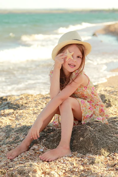 Härlig tjej med ett vackert leende spela barfota i vattnet på stranden — Stockfoto