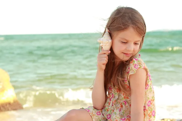 Retrato de uma jovem menina feliz em um vestido de verão com uma concha — Fotografia de Stock