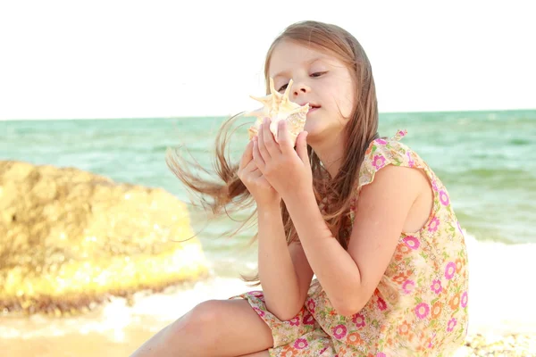 Mutlu bir genç kızın bir yaz aylarında portre seashell ile elbise — Stok fotoğraf