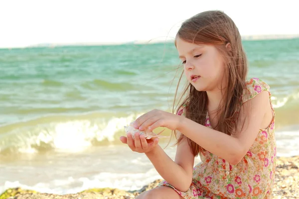Portrait of a happy young girl in a summer dress with a seashell — Stock Photo, Image