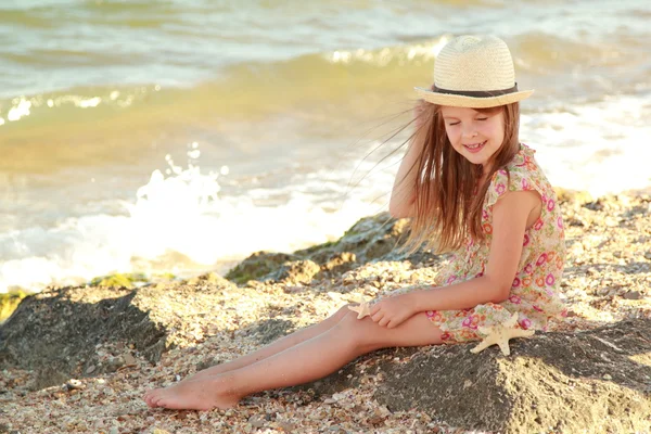 Menina bonita com um lindo sorriso sonhos do mar e olha para a distância — Fotografia de Stock