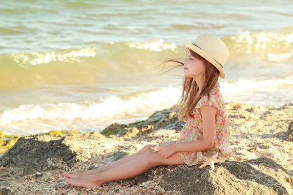 Menina bonita com um lindo sorriso sonhos do mar e olha para a distância . — Fotografia de Stock