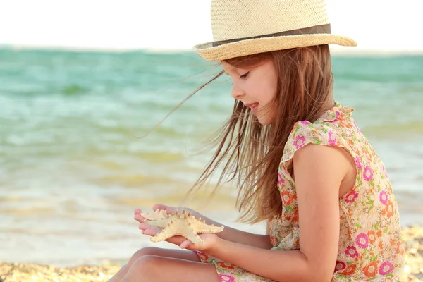 Lovely girl with a beautiful smile playing barefoot in the water on the beach. — Stock Photo, Image