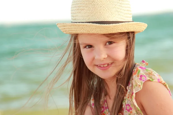 Retrato de una niña que sueña con un sombrero sobre un fondo de un paisaje marino al aire libre . — Foto de Stock