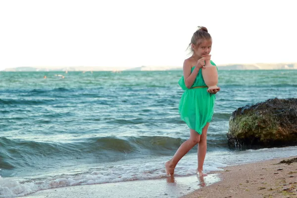 美しいドレスかわいい女の子は、海のギリシャの女神との距離に見えます. — ストック写真