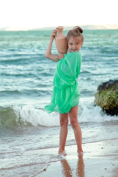 Griechisches lächelndes kleines Mädchen in Tunika hält uralte Amphore. — Stockfoto