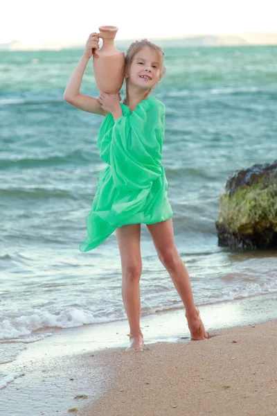 Griego sonriente niña en túnica sostiene ánfora antigua . — Foto de Stock