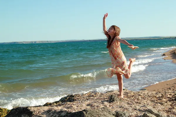 Muito feliz jovem em um vestido bonito e segurando uma estrela do mar . — Fotografia de Stock