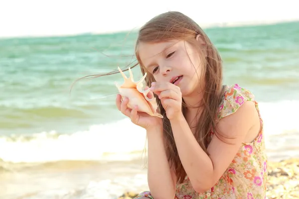 Européen mignonne petite fille tenant un coquillage . — Photo