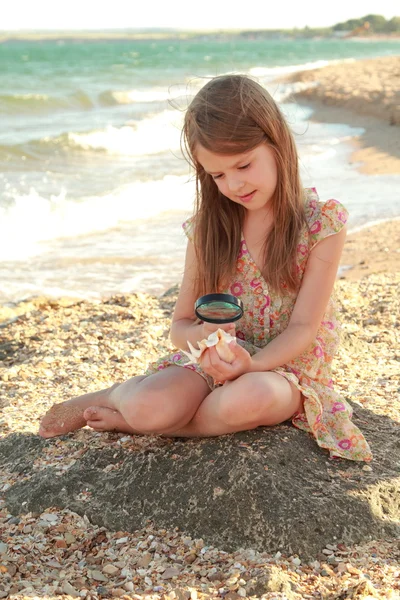 Europeo carino bambina in possesso di una conchiglia . — Foto Stock