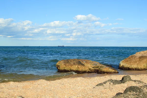 Zee landschap met grote stenen in de zee en op de oever op een zonnige zomerdag. — Stockfoto