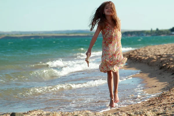 Retrato de una niña sonriente en la playa . — Foto de Stock