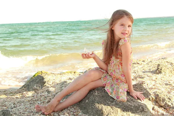 Schönes Mädchen mit einem schönen Lächeln spielt barfuß im Wasser am Strand. — Stockfoto