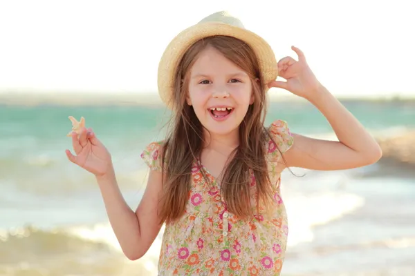 可爱的女孩与一个美丽的笑容，打赤脚在海滩上水. — 图库照片