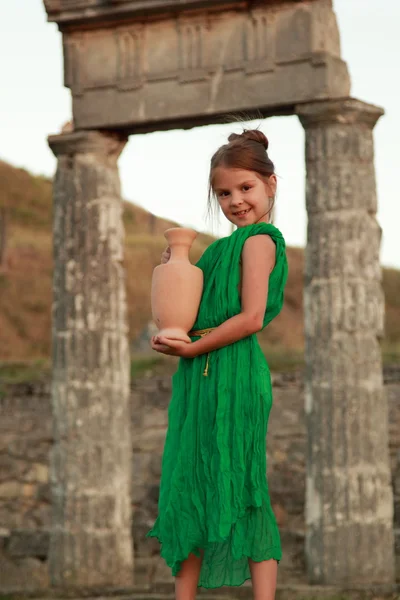 Schönes Mädchen in einem hellen Kleid mit antiken Amphoren auf der Ausgrabung der antiken Stadt — Stockfoto