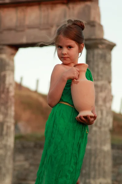 Hermosa joven diosa griega en vestido vintage verde esmeralda celebración de un ánfora antigua — Foto de Stock