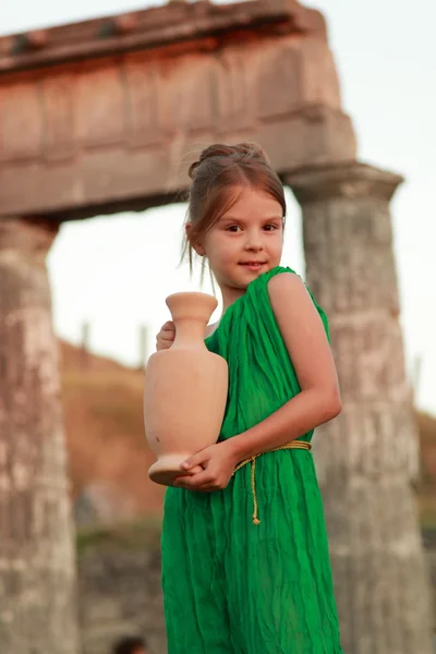 Chica encantadora en el vestido de esmeralda sosteniendo ánfora antigua en la excavación de la antigua ciudad Pantikapaion . — Foto de Stock