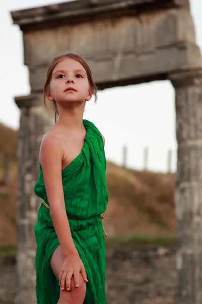 Beautiful little Greek goddess in emerald green dress. — Stock Photo, Image