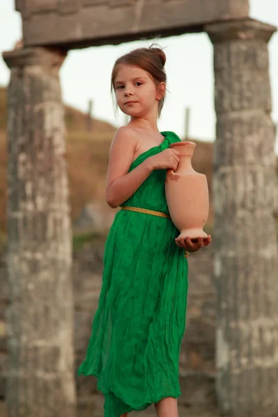 Beautiful little Greek goddess in emerald green dress. — Stock Photo, Image