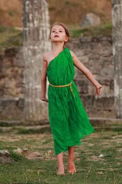 Beautiful little Greek goddess in emerald green dress. — Stock Photo, Image