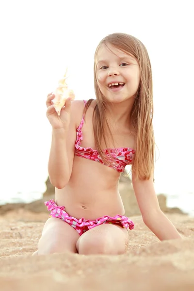 Encantadora chica en traje de baño rosa sosteniendo concha en el Mar Negro . — Foto de Stock