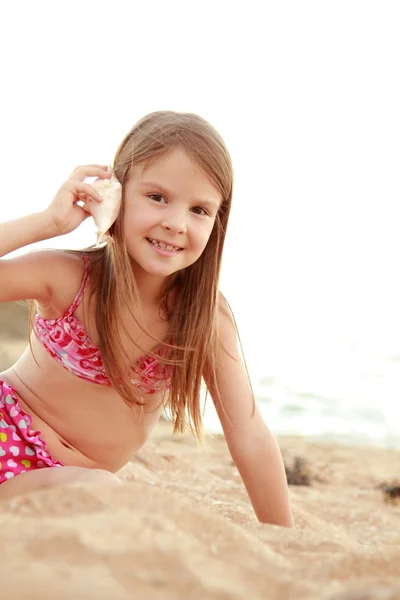 Porträt eines entzückenden kleinen Mädchens mit einer Muschel. — Stockfoto