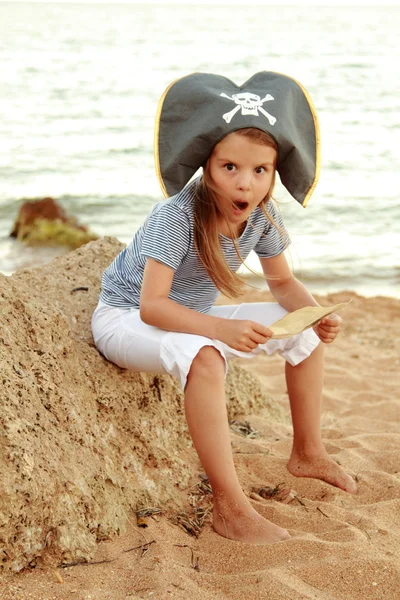 Bella ragazza emotiva vestita da pirata sulla spiaggia in cerca di tesori . — Foto Stock