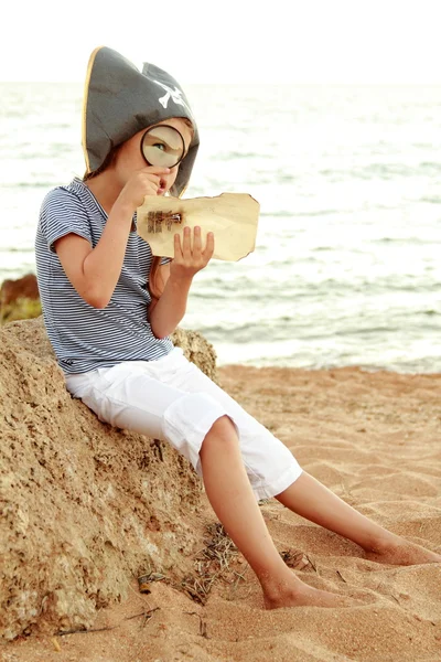 Evil emotional young girl in a hat with the symbol of piracy looking for treasure. — Stock Photo, Image