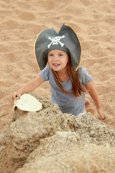 Cute young girl in a pirate hat with a pirate map in hand. — Stock Photo, Image