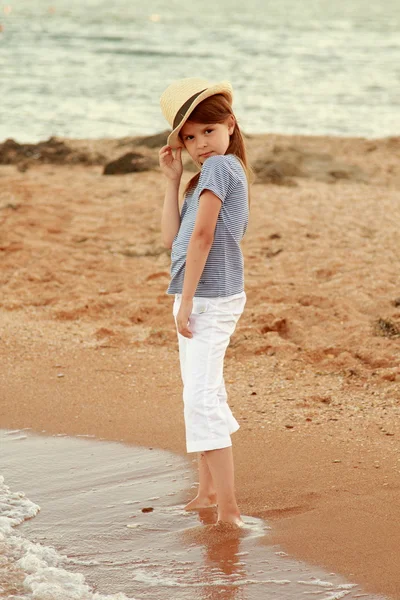 Vackra unga kaukasiska flicka med långt hår och ett sött leende som vilar på oceanen. — Stockfoto