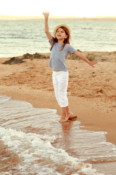 Gün batımında sahilde yürürken, duygusal, neşeli genç kız. — Stok fotoğraf